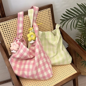 Detail of pink and green checkered canvas shoulder bags with cute 3D flower charms