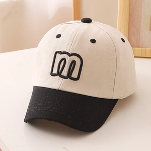 Detail of cotton baseball cap with two-tone design and embroidered letter m logo