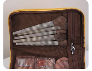 Interior detail of house-shaped cosmetic bag showing brush slots and mesh pocket