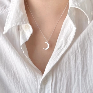 Elegant 925 sterling silver crescent moon necklace with a single diamond on a model