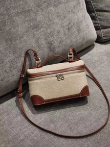 Elegant beige canvas and brown leather handbag with top handle and long shoulder strap