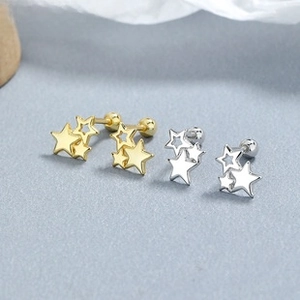 Detail view of gold and silver S925 sterling silver star earrings with zircon inlay