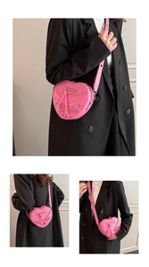Sac bandoulière rose en forme de cœur style motard illustrant la taille sur un mannequin