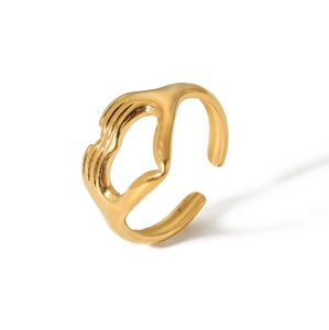 Detail of golden hug ring showing the unique hand-shaped design and mirror finish surface