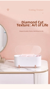 Detail of white textured makeup storage box with rose gold feet and clear lid on marble