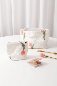 Close-up of quilted floral makeup bags with tulip embroidery and flower zipper pull