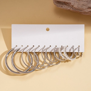 Close-up of 12-piece silver hoop earring set with pearls and textured geometric designs