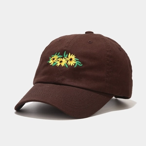 Detail of sunflower embroidery on caramel brown cotton baseball cap with curved brim