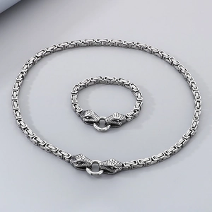Detailed shot of silver double snake head clasps on thick square link chain jewelry set