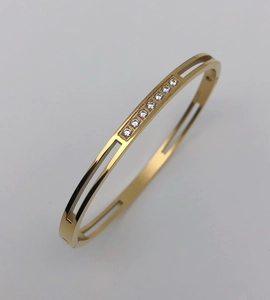 Close-up of gold-plated titanium steel hollow bangle featuring eight centered crystals