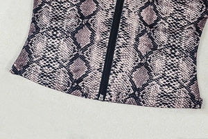 Close-up of snake skin print crop top featuring a central black zipper closure detail