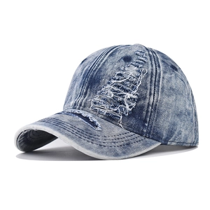 Vintage distressed blue denim baseball cap with stylish ripped holes and curved brim