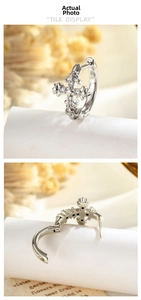 Détail de créole en croix avec zircons blancs et motif d'iris gothique en or café