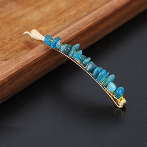 Macro shot of blue natural crystal stones hand-wrapped on a golden metal hair clip