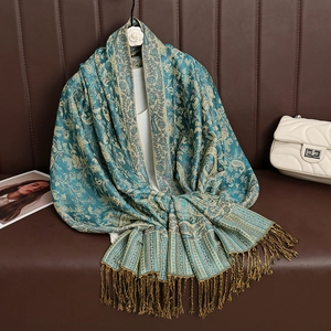 Close-up of teal and gold paisley patterned pashmina scarf with elegant fringe detail