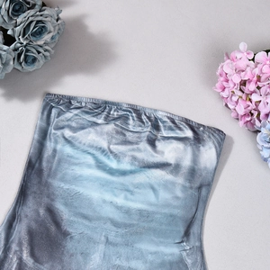 Detailansicht eines rückenfreien Jumpsuits aus elastischem Stoff mit blauem Farbverlauf