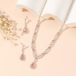 Detail of silver claw chain jewelry set with orange teardrop gemstones and clear rhinestones