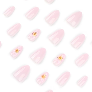 Short almond press-on nails in pale pink with 3D floral accents and glossy finish