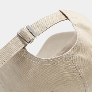 Gros plan sur la boucle réglable et les coutures de la casquette beige en coton