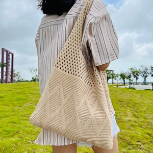 Detail of beige crochet tote bag with diamond pattern and mesh texture on outdoor model