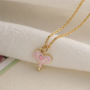 Collana con ciondolo a lecca-lecca a cuore rosa e catena d'oro su tessuto bianco soffice