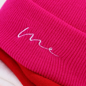 Fashionable ribbed knit beanie featuring minimalist embroidery in vibrant pink color