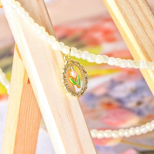 Elegant gold tulip pendant necklace with pearl chain featuring pink enamel floral details