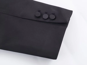 Detail of black blazer cuff with satin finish and three matching fabric-covered buttons