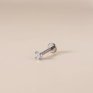 Macro shot of silver G23 titanium labret stud with a clear zircon and flat back base