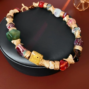 Macro shot of vintage ceramic flower necklace with colorful beads and gold T-bar clasp