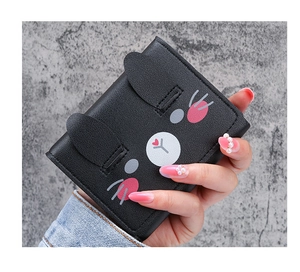 Detailed view of the cute cartoon cat face design on the black short tri-fold wallet