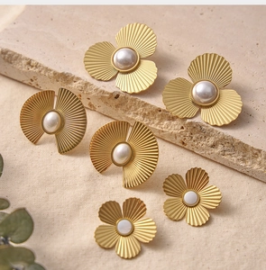 Détails de boucles d'oreilles vintage dorées avec perles sur un support en pierre texturé