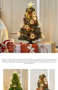 Detail of warm white LED tabletop Christmas tree with snowflakes and red berries