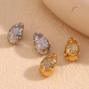 Detail of luxury water drop earrings featuring pave butterfly zircons in gold and silver
