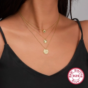 Three-layer 925 sterling silver evil eye necklace with layered gold pendants on model