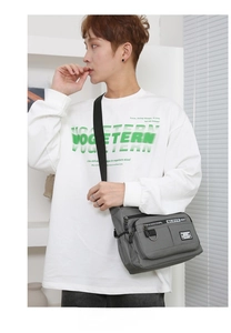 Detailed view of grey waterproof crossbody bag with multiple zippers and adjustable strap