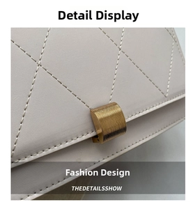 Detail of quilted leather texture and golden metallic lock on a cream shoulder bag