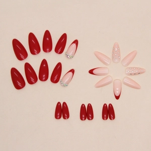 Glossy red almond press-on nails with rhinestone accents and French tip design