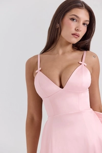 Close-up of pink satin dress showing V-neck design and delicate bow decoration
