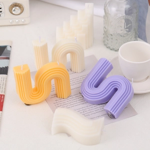 Artistic U-shaped scented candles in multiple colors on a vintage aesthetic background