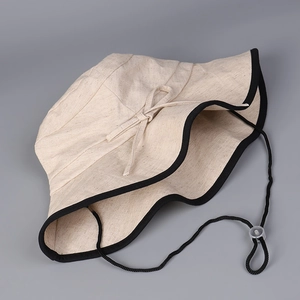 Close-up of cotton linen sun hat with black contrast trim and adjustable chin cord