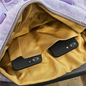 Inside view of purple canvas backpack with dual inner pockets for large capacity storage