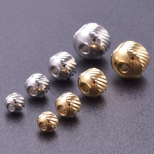 Macro shot of 18k gold and silver stainless steel textured beads in various sizes