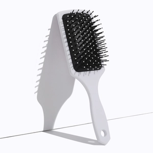 Macro detail of square air cushion hair brush with white bristles and round massage tips