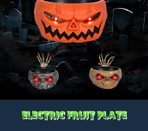 Macro shot of Halloween electric fruit plate with glowing red eyes and moving skull hands