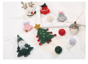 Detail of handmade wool felt Christmas tree ornaments and deer on a cozy white display
