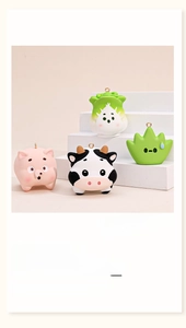 Macro shot of cute PVC cartoon pig, cow, and cabbage charms for backpacks or keyrings