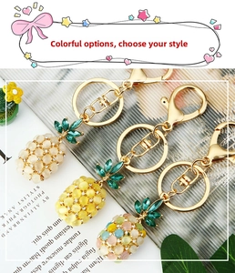 Close-up of cat-eye stone pineapple keychains with gold plating and sparkling crystals