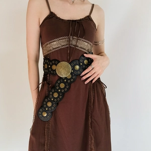Detail of western vintage belt with golden metal rings on a brown lace dress