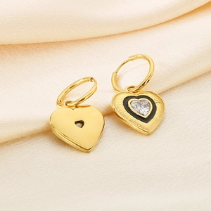 Vintage 18K gold heart earrings with black enamel and zircon on silk background